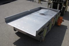In-line spreader for plate freezer or blancher